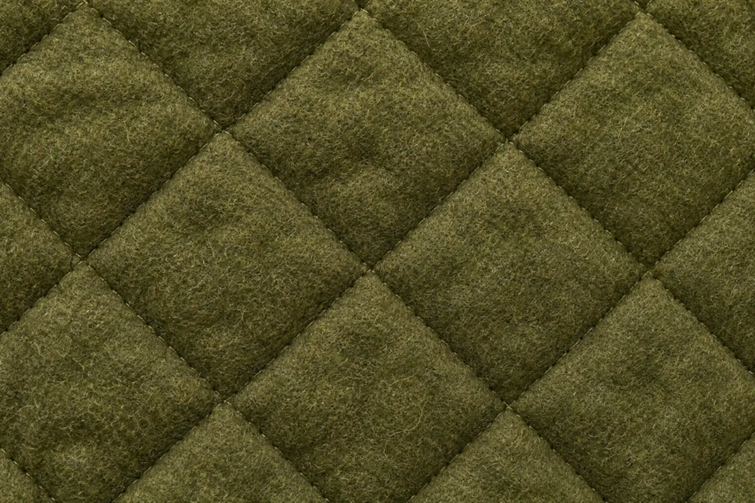 Close-up of quilted olive wool fabric with a stitched diamond pattern